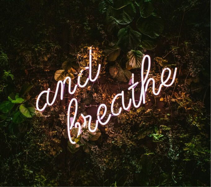 Sign reading 'and breathe' surrounded by leaves